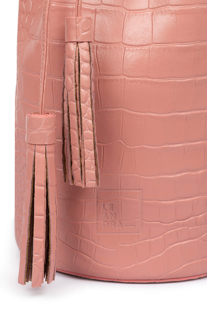 Bolso tipo mini bucket grabado en coco color rosa Leandra. Bolsos de piel Leandra imagen detalle borlas