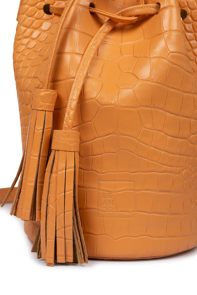 Bolso piel mini bucket bag de piel grabada en coco color pomelo Leandra. Bolsos de piel made in Spain. Imagen detalle de borlas